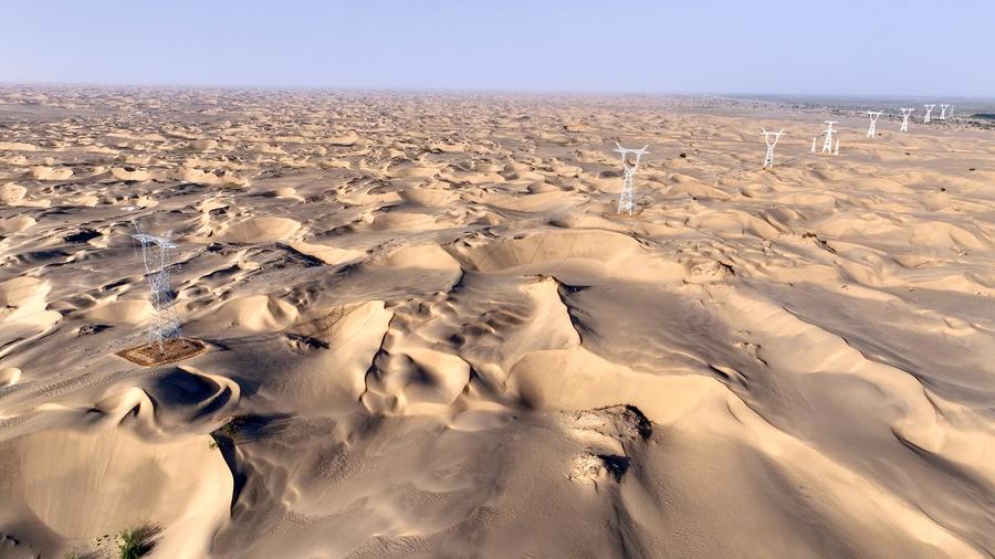 25 جون 2025 ۔ تصویر میں شمال مغربی چین کے سنکیانگ ویغور خود اختیار علاقے میں صحرائے تکلامکان سے گزرتا ہوا 750 کلو والٹ کی ترسیل اور تبدیلی کے منصوبے کا ایک حصہ دیکھا جا سکتا ہے ، (تصویر: ما یوان/شنہوا)