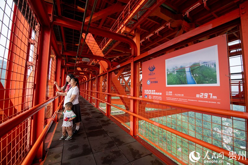 چین کے صوبے سیچوان کے شہر چھنگ دو سے آئی ہوئی سیاح ، لی اور اس کے خاندان کے افراد ، چین کے جنوب مغربی صوبے گوئے جو میں دریائے بالنگ کے پل کے اندرونی حصے کی سیر کر رہے ہیں۔ (پیپلز ڈیلی آن لائن/وانگ چی یو )