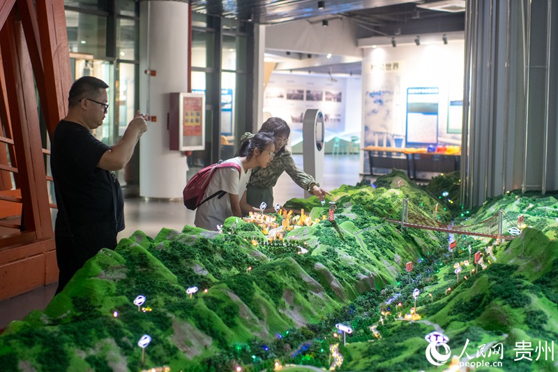 چین کے جنوب مغربی صوبے گوئے جو میں سیاح بالنگ ریور برج میوزیم میں اس کے ماڈل کو دیکھ رہے ہیں۔ (پیپلز ڈیلی آن لائن/وانگ چی یو )