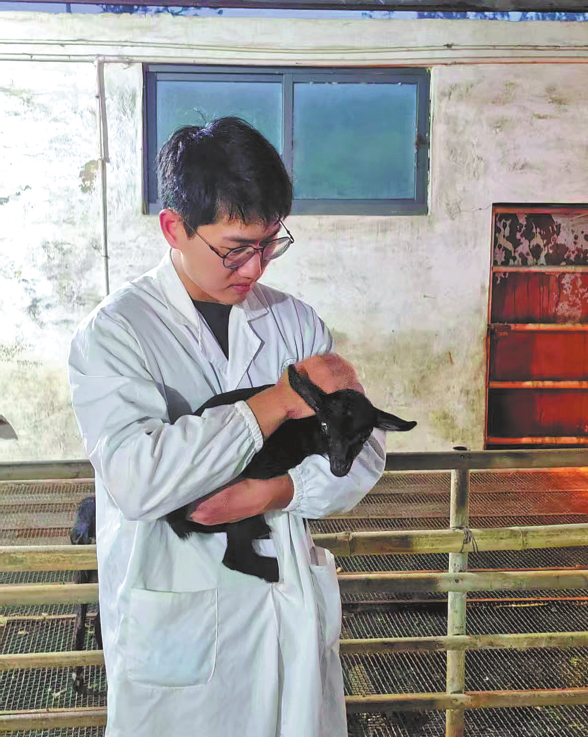 گوانگ دونگ اوشن یونیورسٹی میں ایک محقق ، دنیا کی پہلی "جین- ایڈیٹ "سیاہ بکری کوگود میں اٹھائے ہوئے ہے (تصویر : چائنا ڈیلی)