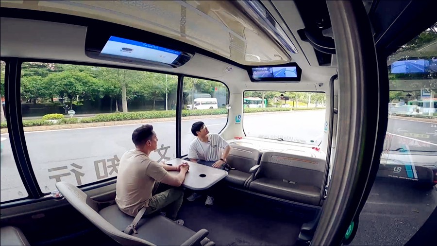 ہسپانوی سیاح الوارو لاگو (بائیں سے پہلے) گوانگجو میں ایک خود کار بس کا تجربہ کر رہے ہیں۔ (پیپلز ڈیلی آن لائن/یوان منگ)