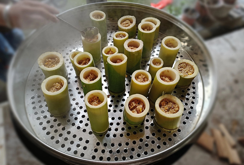 صوبہ جیانگ شی کی کاونٹی سوئیچھوان کے گاوں بائی شوئی میں بانس کی نلکیوں میں لیس دار چاول پکائے جا رہے ہیں۔ (تصویر انٹرویو دینے والے کی جانب سے فراہم کی گئی ہے)