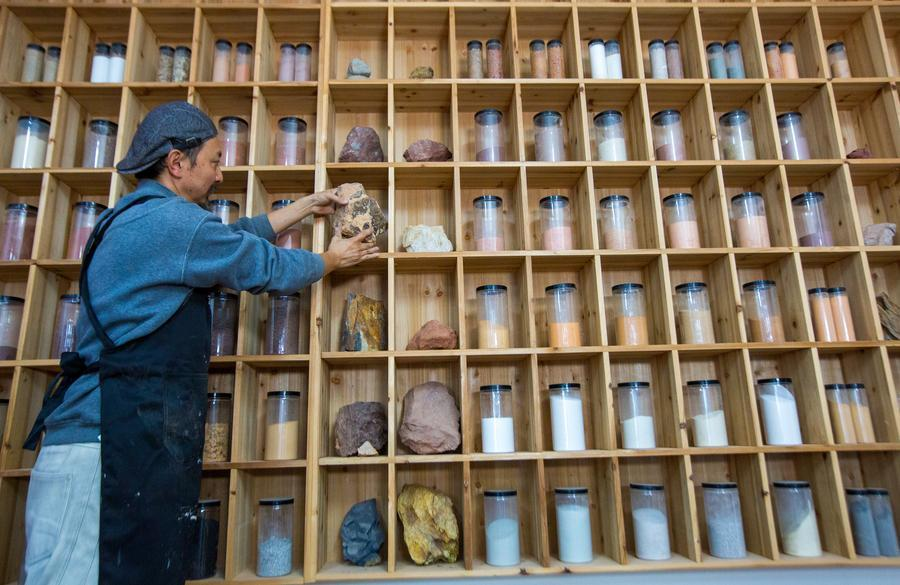 22 دسمبر 2025 ۔ وویی شان  میں ایک فنکار مختلف رنگوں کے   پتھروں اور مٹی  کے باریک پسے ہوئے  کو پاوڈر کو طاقوں میں  رکھ رہا ہے ۔(چھین ینگ/شنہوا)