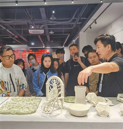 چین کے صوبے جیانگشی میں ، مائیکرو سیرامک ٹیکنالوجی (جیانگ شی ) کارپوریشن لمیٹڈ کے عملے کا رکن ، فیکٹری کا دورہ کرنے والے افراد کو تھری ڈی پنٹڈ سیرامکس کے بارے میں بتا رہا ہے۔ (تصویر انٹرویو دینے والے کی جانب سے فراہم کی گئی ہے)