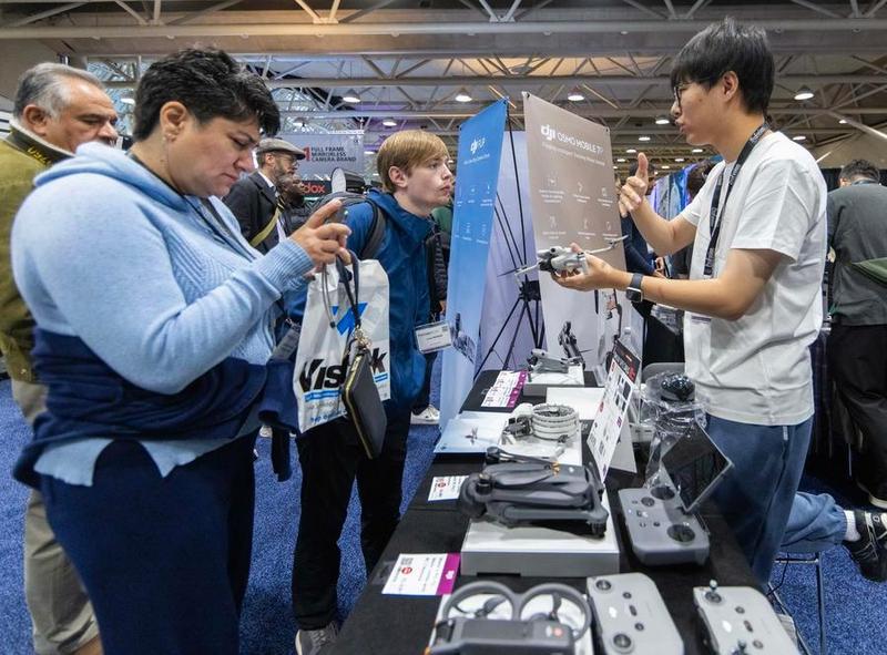 نومبر 2025 ٹورنٹو، کینیڈا . پروفیوژن ایکسپو 2025 کے دوران لوگ DJI بوتھ میں نئی مصنوعات دیکھ رہے ہیں۔( تصویر/شین ہوا)