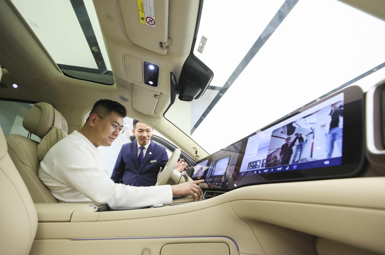 چین کے صوبے شان دونگ میں ایک شخص نئی توانائی کی گاڑی میں بیٹھ کر اس کے فیچرز کا جائزہ لے رہاہے۔(تصویر۔ جاو چی روئی )