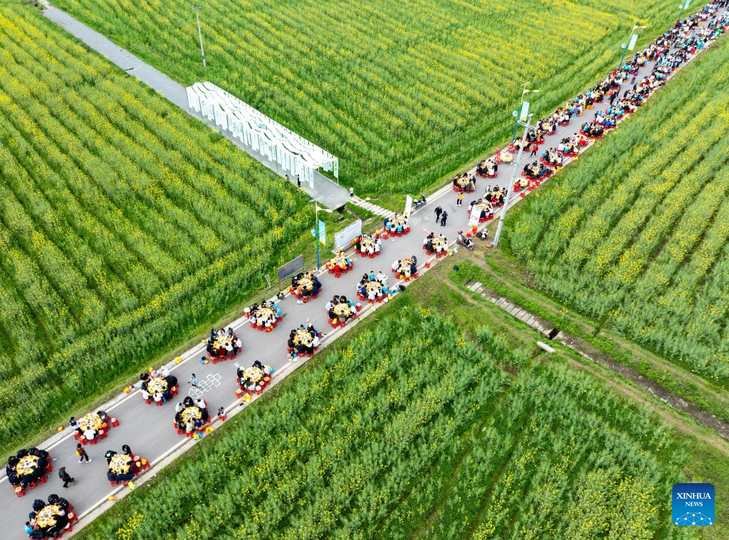 21 مارچ 2026 کو جنوب مغربی چین کے صوبے سیچوان کے شہر گوانگ آن میں سرسوں کے پھولوں کے کھیتوں کے درمیان ضیافت سے لطف اندوز ہوتے لوگوں کا فضائی منظر۔ (جانگ گو شینگ / شنہوا)