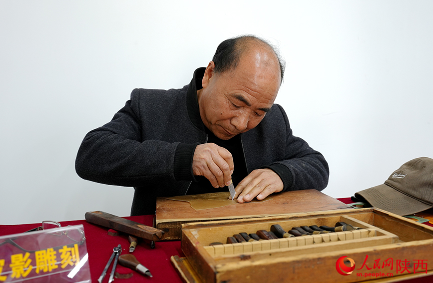 شمال مغربی چین کے صوبے شائنشی کے گاؤں شوانگ چوان میں  چھین یی ون شیڈو پتلی بنانے میں مصروف ہیں۔ (پیپلز ڈیلی آن لائن۔سون تھینگ )