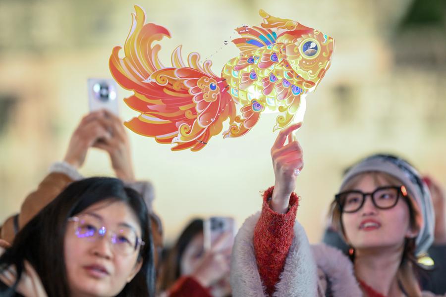 25 جنوری 2025۔ مشرقی چین کے صوبے جیانگسو کے شہر ووشی کے تاریخی سیاحتی مقام حوئی شان میں سیاح خاتون مچھلی کی شکل کی روایتی چینی لالٹین تھامے ہوئے ہیں۔ (شنہوا/ وانگ شوجونگ)