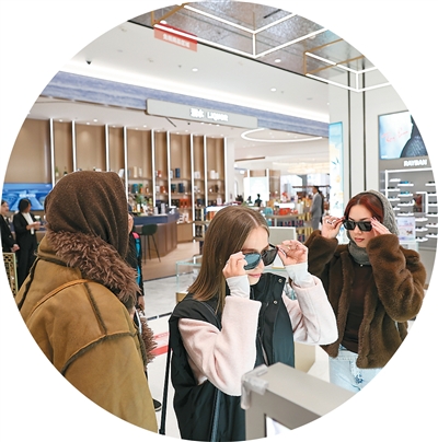 شمالی چین کے شہر تھیان جن کی پہلی ، ڈاؤن ٹاؤن ڈیوٹی فری شاپ میں غیر ملکی سیاح دھوپ کے چشمے منتخب کر رہی ہیں ۔ (شِنہوا/سن فین یوئے)