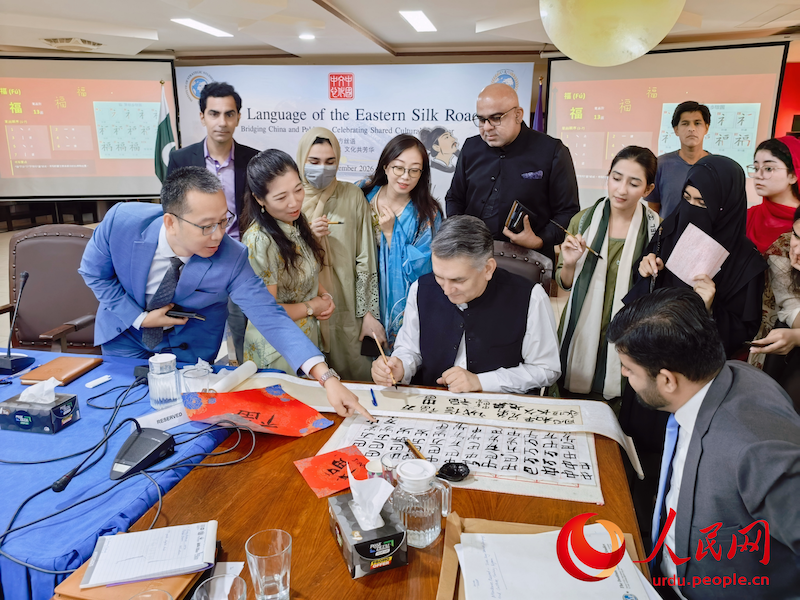 چینی خطاطی کی عملی نشست میں شرکا روایتی چینی خطاطی کا تجربہ کر رہے ہیں۔ (تصویر: چائنا کلچرل سینٹر اِن پاکستان)