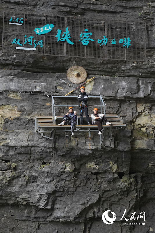 چین کے صوبہ گوئے جو کی کاونٹی سُوئی یانگ میں واقع شوانگ حہ غار میں ، 'Via Ferrata' کا تجربہ کرنے والے مہم جو ، بلندی پر موجود پلیٹ فارم پر بیٹھے "کلف سائیڈ نائٹ کافی" کا کپ ہاتھ میں تھامے اردگرد کے شاندار مناظر سے لطف اندوز ہو رہے ہیں۔ (فوٹو۔چھین فان)